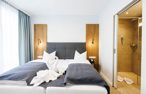 The double bed in the Comfort Plus Apartment has two swans folded out of towels to form a heart.