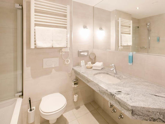 Ein modernes Badezimmer mit Badewanne, WC und Waschbecken.