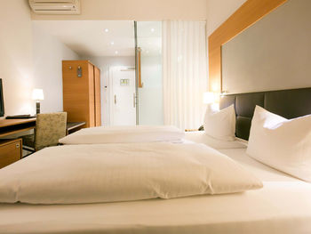 Zwei Kissen und zwei Bettdecken liegen auf einem Doppelbett im Businesszimmer