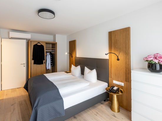 La moderna camera da letto con armadio e letto matrimoniale dell'appartamento Deluxe XL.