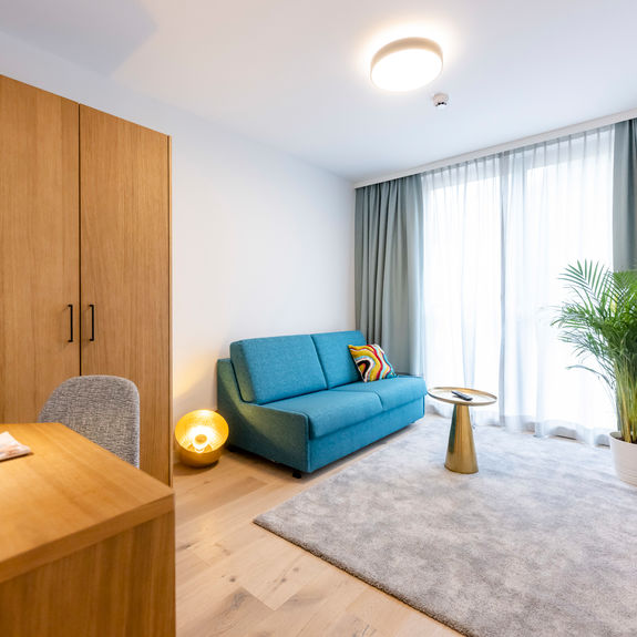 The modernly furnished additional room with couch, carpet, wardrobe, desk and much more in the Delux XL apartment.