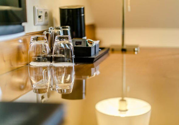 Ein paar Gläser stehen auf einen Schreibtisch mit Glasplatte.