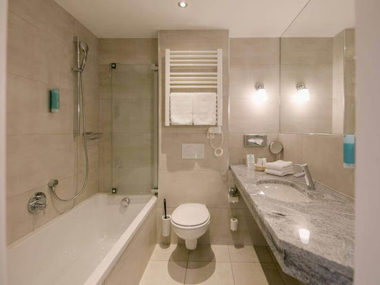 Ein modernes Badezimmer mit Badewanne, WC und Waschbecken.