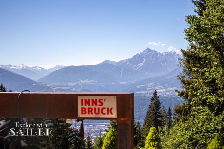 Blick über das Inntal und die Tiroler Bergwelt bei der Umbrüggler Alm, im Vordergrund ein Fahrradabstellplatz.