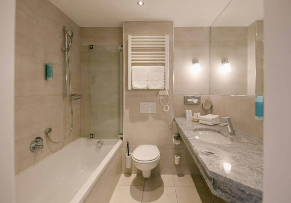 Ein modernes Badezimmer mit Badewanne, WC und Waschbecken.