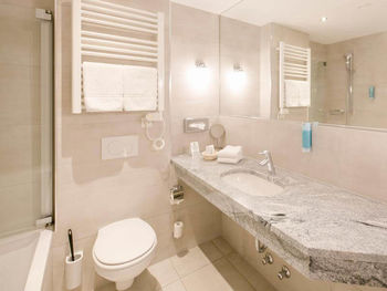 Ein modernes Badezimmer mit Badewanne, WC und Waschbecken.