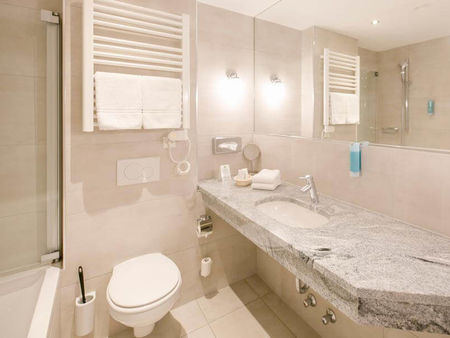 Ein modernes Badezimmer mit Badewanne, WC und Waschbecken.