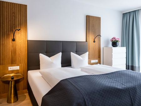 The modern double bed in the bedroom of the Delux XL apartment.