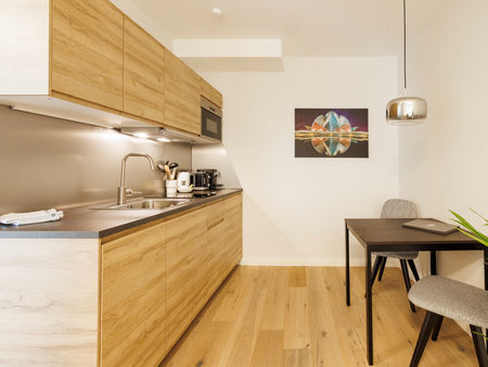 Die kleine Küche im Apartment mit Tisch und Stühlen.