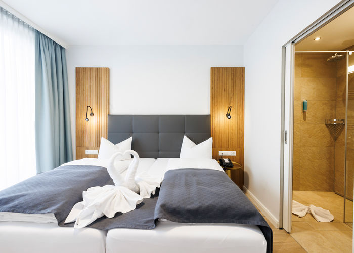 The double bed in the Comfort Plus Apartment has two swans folded out of towels to form a heart.
