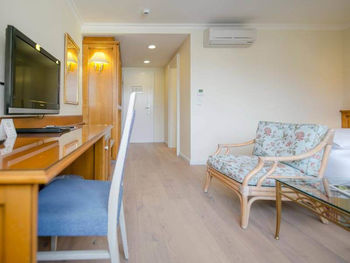 Das Klassik Zimmer im Hotel Sailer mit einem Schreibtisch, einem Holzboden und einer Bank im Blumenmuster