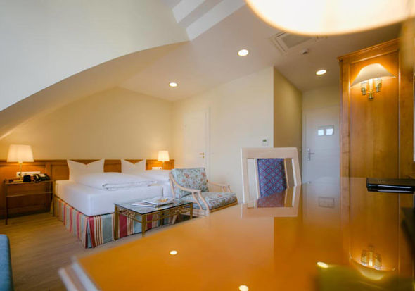 Ein Schreibtisch ein weiches Doppelbett und Sitzgelegenheiten mit den dazu passenden Glastisch haben in diesen Superior Zimmer platz.