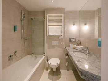 Ein modernes Badezimmer mit Badewanne, WC und Waschbecken.