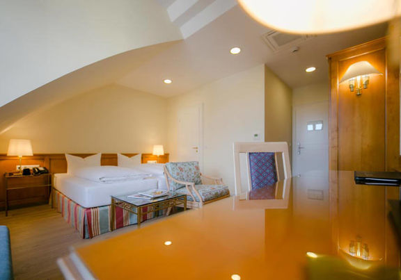 Ein Schreibtisch ein weiches Doppelbett und Sitzgelegenheiten mit den dazu passenden Glastisch haben in diesen Superior Zimmer platz.