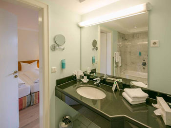 Il bagno ha un grande specchio e un lavabo nero lucido.