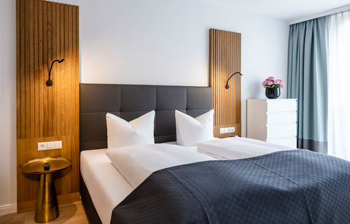 The modern double bed in the bedroom of the Delux XL apartment.