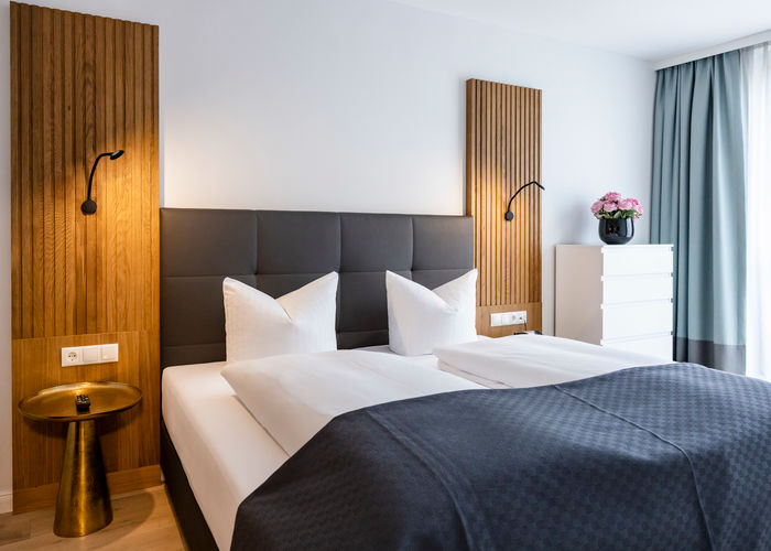 The modern double bed in the bedroom of the Delux XL apartment.
