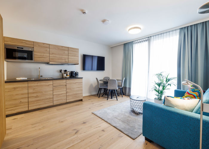 The modern, fully equipped kitchen-living room in the Deluxe Plus Apartment.
