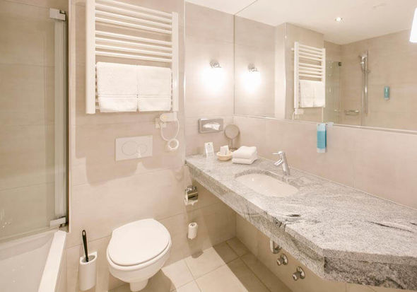 Ein modernes Badezimmer mit Badewanne, WC und Waschbecken.