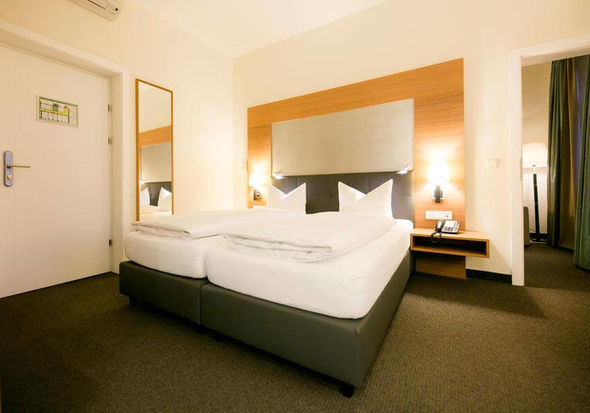 Un grande letto matrimoniale si trova in una grande stanza con un tappeto