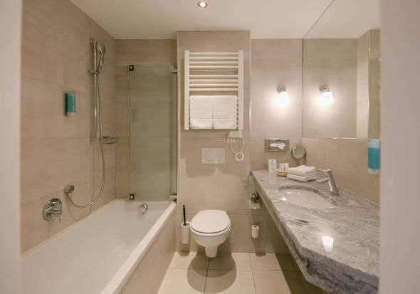 Ein modernes Badezimmer mit Badewanne, WC und Waschbecken.