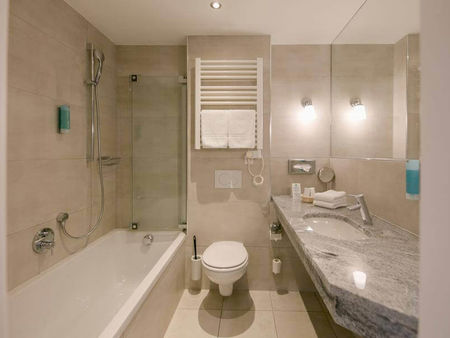 Ein modernes Badezimmer mit Badewanne, WC und Waschbecken.