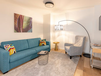 Il moderno soggiorno dell'appartamento Delux XL con divano, tappeto, tavolo e molto altro.