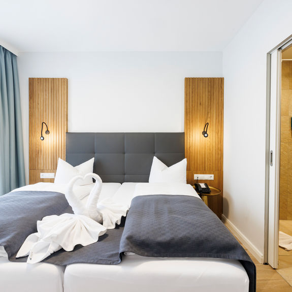 The double bed in the Comfort Plus Apartment has two swans folded out of towels to form a heart.