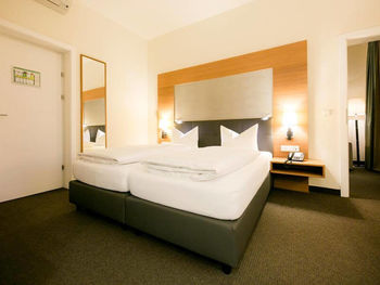 Un grande letto matrimoniale si trova in una grande stanza con un tappeto