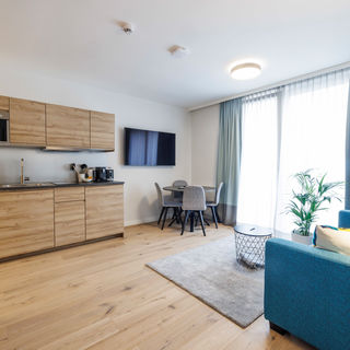 The modern, fully equipped kitchen-living room in the Deluxe Plus Apartment.