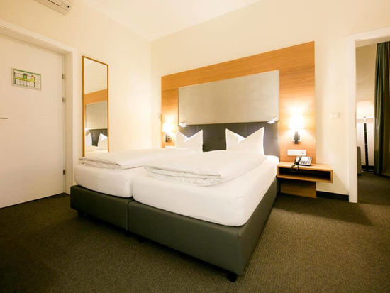 Un grande letto matrimoniale si trova in una grande stanza con un tappeto