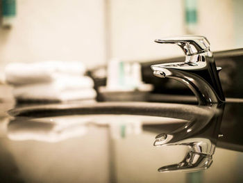 Eine silberne Armatur spiegelt sich auf den sauberen, schwarzen Waschbecken wieder.