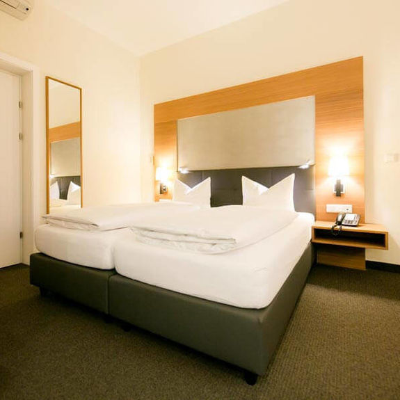 Ein großes Doppelbett steht in einem großen Zimmer mit einem Teppichboden