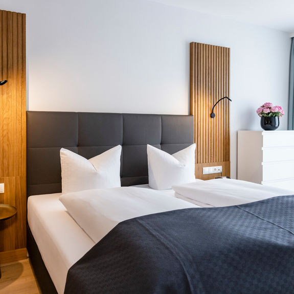 The modern double bed in the bedroom of the Delux XL apartment.