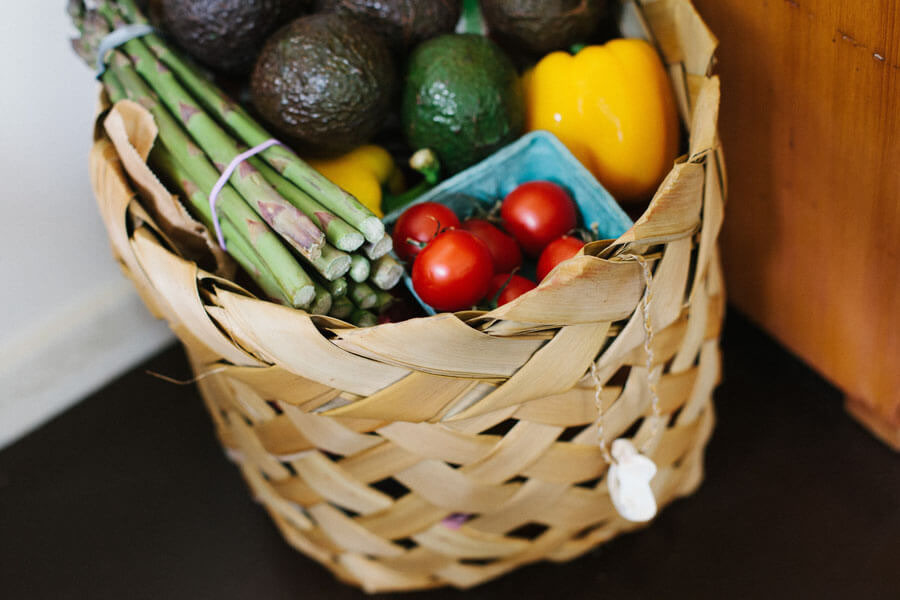 A shopping bag with several different foods and vegetables in it