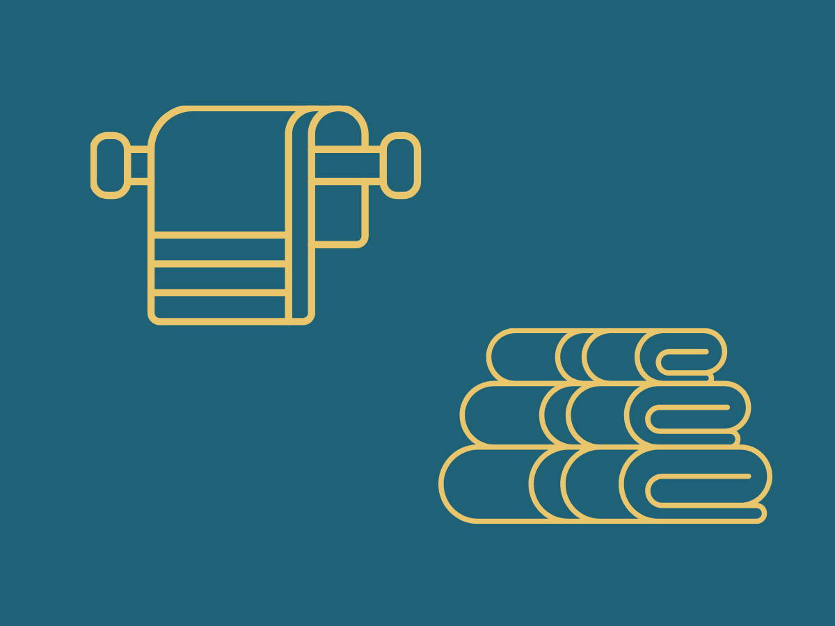 Several clean white towels lie on a black stool