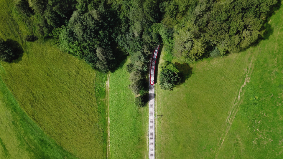 Nachhaltiges Reisen in Innsbruck Zug fährt durch die grüne Landschaft bei Innsbruck