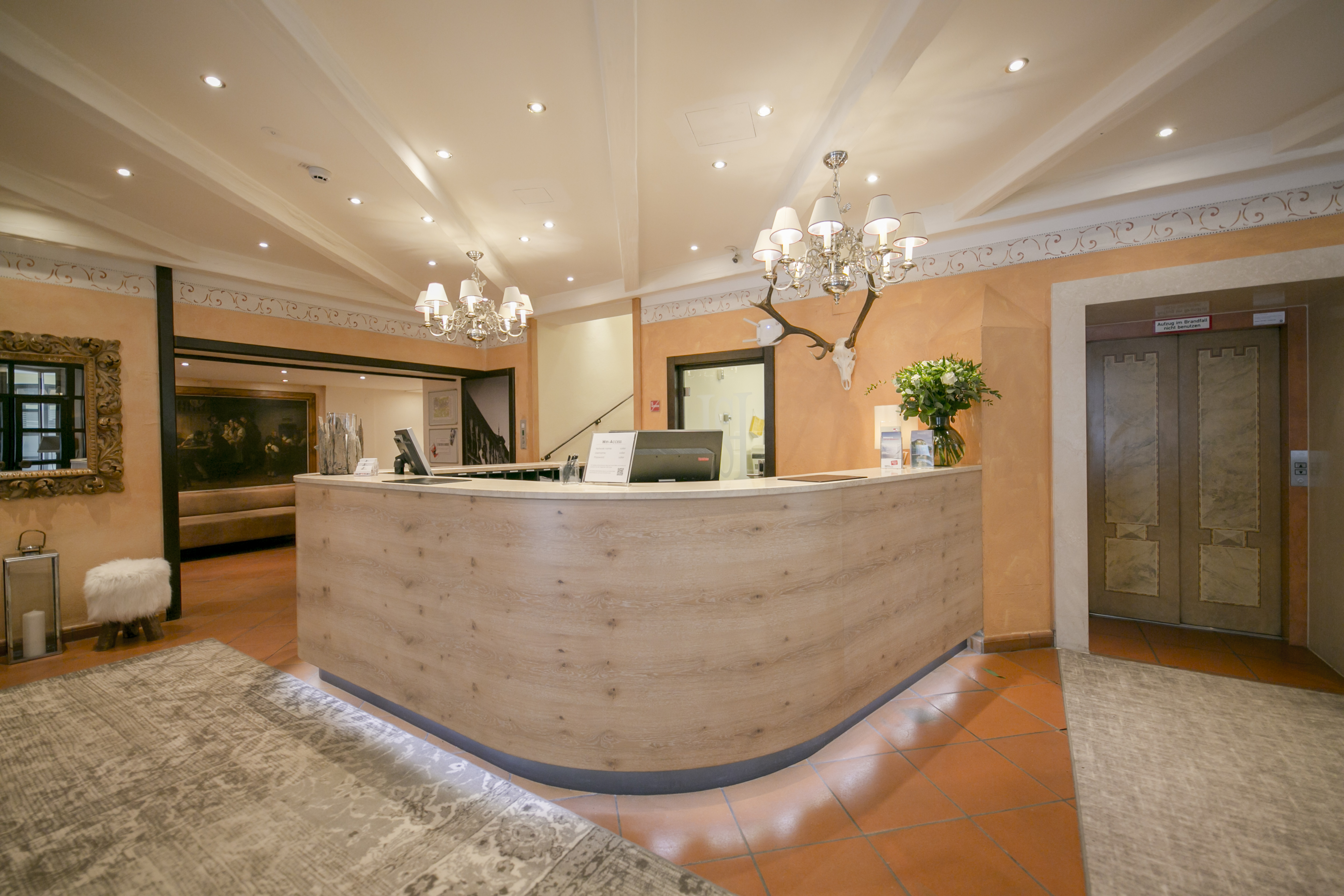 Luminosa area reception con bancone in legno, lampadari decorativi e ambiente invitante