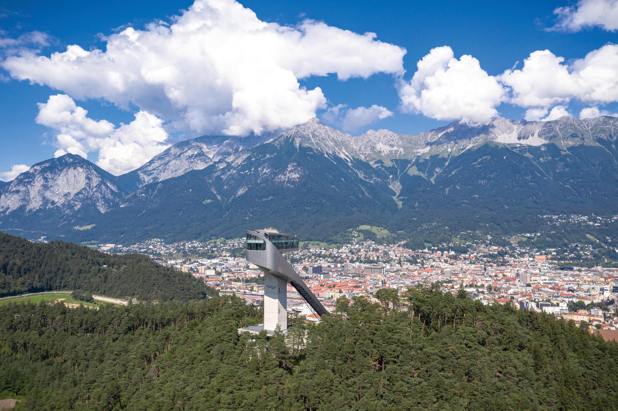 Trampolino di lancio con panorama della città e delle montagne sotto un cielo azzurro