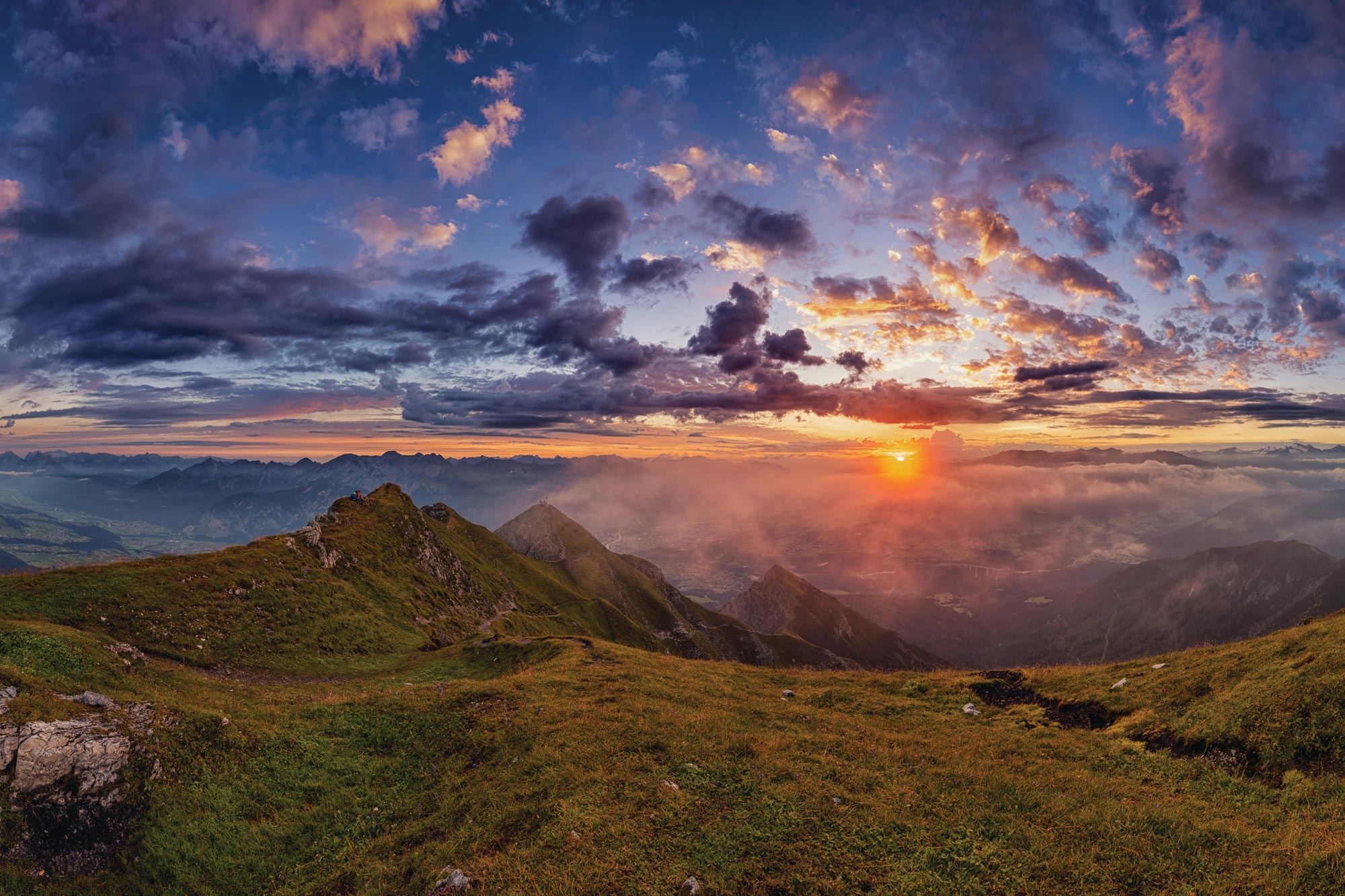 Breathtaking sunset over a mountain landscape with dramatic cloud formations.