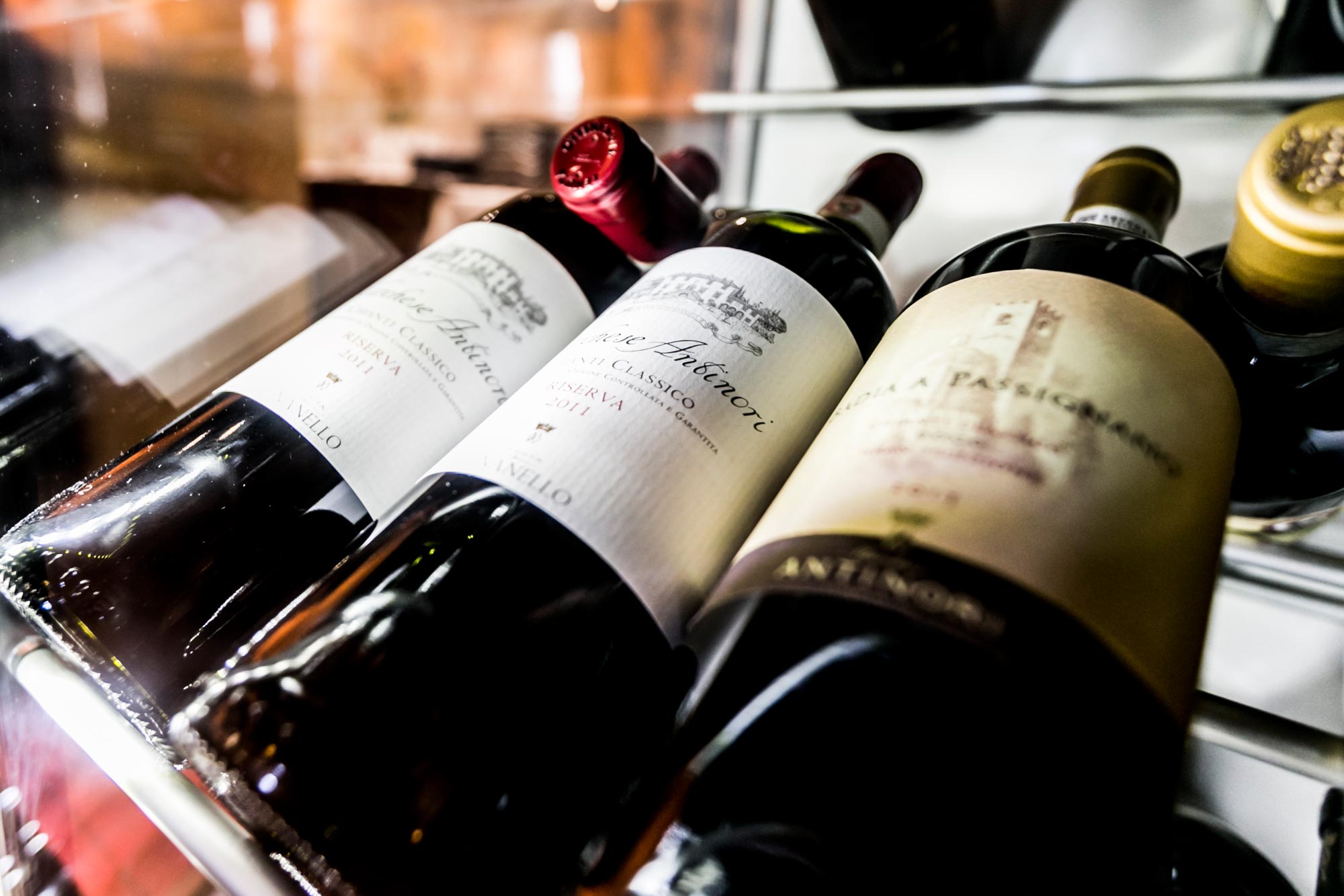 Flaschen mit edlen Weinen in einem stilvollen Regal präsentiert.