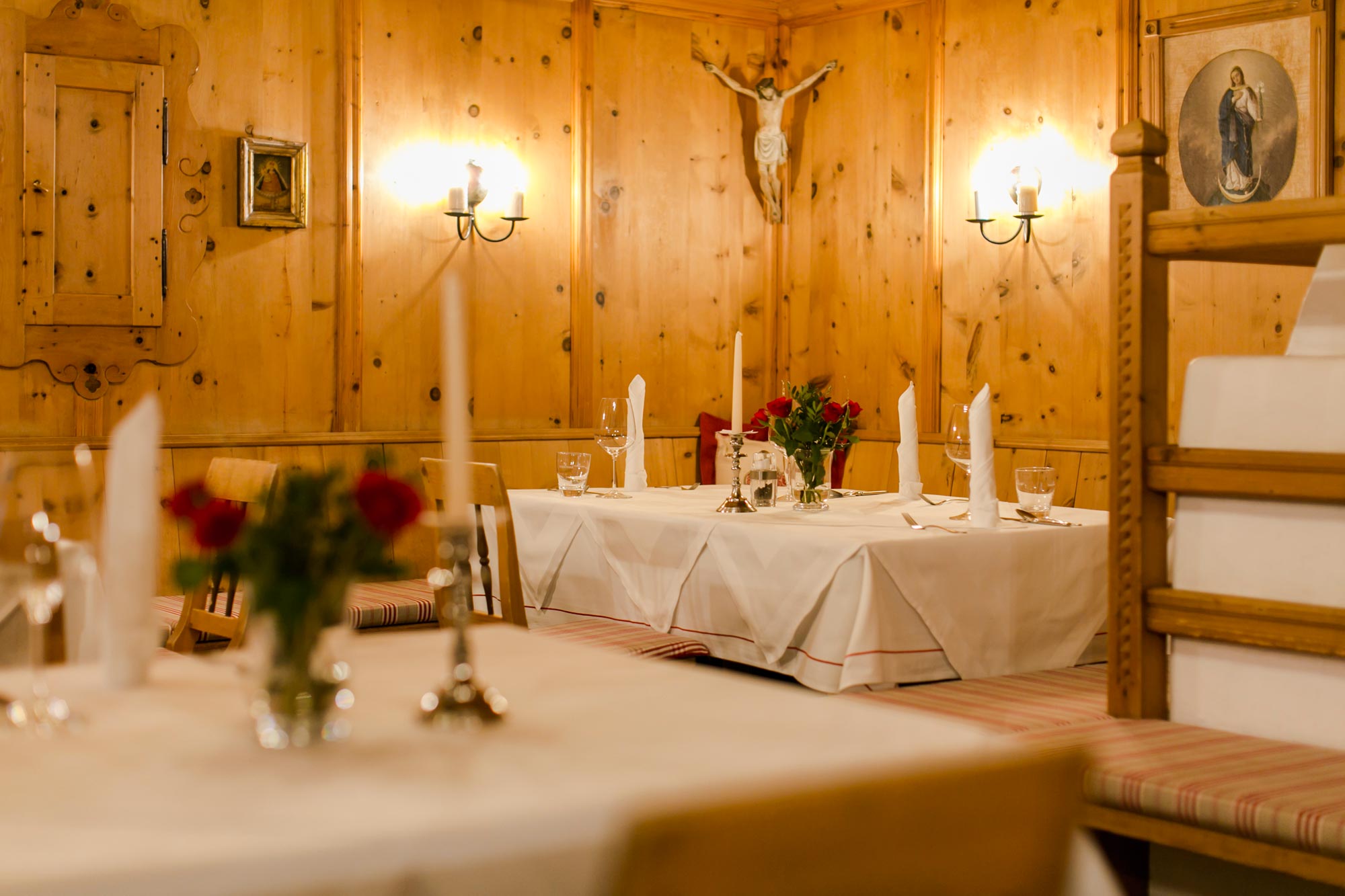 Cozy wood paneling with soft lighting and festively laid tables.
